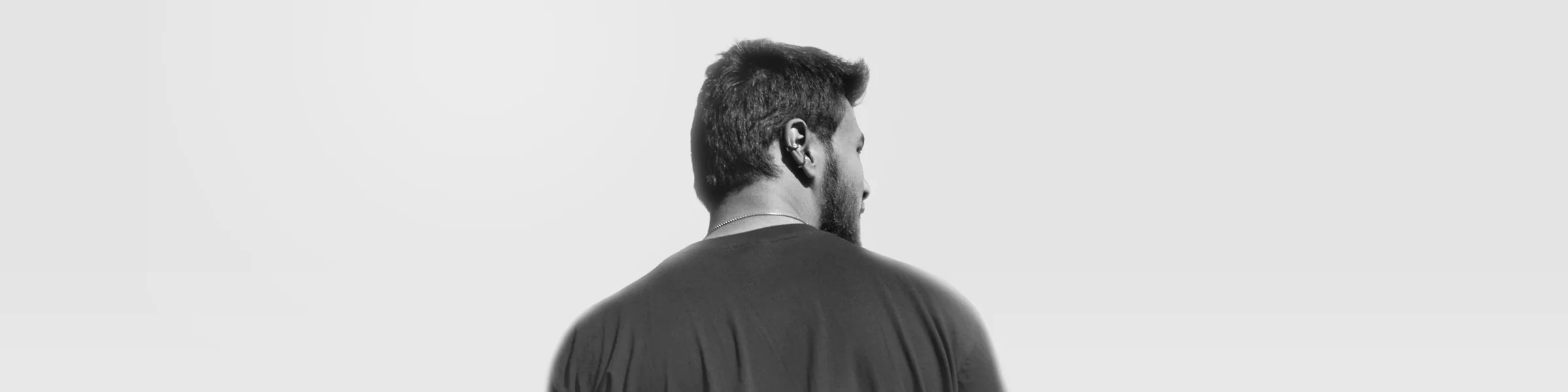 Wide black-and-white portrait of Erata facing away from the camera.